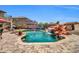 Resort-style pool with rock waterfall feature surrounded by beautiful landscaping at 11965 W Monte Vista Rd, Avondale, AZ 85392