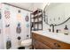Bright bathroom featuring modern vanity, round mirror, and stylish pineapple-themed shower curtain at 1209 W Colter St, Phoenix, AZ 85013