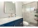 Stylish bathroom featuring a blue vanity with marble countertop, gold fixtures, and a tiled walk-in shower at 1209 W Colter St, Phoenix, AZ 85013