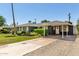 Inviting single-story home with a carport, well-manicured landscaping, and a long driveway at 1209 W Colter St, Phoenix, AZ 85013