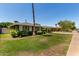 Well-maintained front yard with lush lawn, mature trees, and a charming single-story home at 1209 W Colter St, Phoenix, AZ 85013