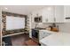 Stylish kitchen with white cabinetry, stainless steel appliances, and unique wallpaper accent at 1209 W Colter St, Phoenix, AZ 85013