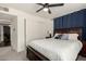 Comfortable primary bedroom with a ceiling fan, large window and blue curtains with closet access at 1209 W Colter St, Phoenix, AZ 85013