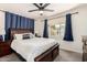 Comfortable main bedroom with a ceiling fan, large window and blue curtains with soft neutral accents at 1209 W Colter St, Phoenix, AZ 85013