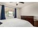 Comfortable primary bedroom with a ceiling fan, large window and blue curtains with dark wood dresser at 1209 W Colter St, Phoenix, AZ 85013