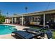 Relaxing backyard featuring a pool, lounge chairs, and covered patio with comfortable seating at 1209 W Colter St, Phoenix, AZ 85013