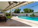 Backyard pool area with lounge chairs, lush green lawn, and covered seating area at 1209 W Colter St, Phoenix, AZ 85013