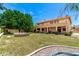 Large backyard with mature landscaping, a built-in fire pit, and plenty of open space at 13324 W Annika Dr, Litchfield Park, AZ 85340