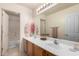 Bathroom with dual sinks, large mirror, and updated lighting at 13324 W Annika Dr, Litchfield Park, AZ 85340