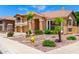 Charming two-story home featuring desert landscaping, mature palm trees, and a welcoming front entrance at 13324 W Annika Dr, Litchfield Park, AZ 85340