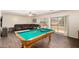 Game room featuring a pool table, comfy leather sofa, and sliding glass doors to the outside at 13324 W Annika Dr, Litchfield Park, AZ 85340