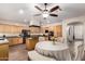 Spacious eat-in kitchen with wooden cabinets, black appliances, and a cozy dining area under a ceiling fan at 13324 W Annika Dr, Litchfield Park, AZ 85340