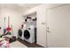 Functional laundry room with washer, dryer, and storage shelves at 13324 W Annika Dr, Litchfield Park, AZ 85340