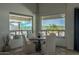 Cozy dining area with round table, seating for four, and views of the backyard oasis through large windows at 14332 E Bobwhite Way, Scottsdale, AZ 85262