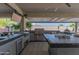 Luxurious outdoor kitchen with stainless steel grill, TV, and tile countertops, perfect for entertaining at 14332 E Bobwhite Way, Scottsdale, AZ 85262