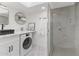 Modern bathroom featuring a glass shower, sleek vanity, and laundry setup at 1509 W Kiowa Ave, Mesa, AZ 85202