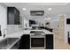 Open-concept kitchen with black cabinets, stainless steel appliances, white countertops and views into the living area at 1509 W Kiowa Ave, Mesa, AZ 85202