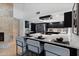 Contemporary kitchen showcasing an island with bar stools, black cabinetry, stainless steel appliances, and a stone fireplace at 1509 W Kiowa Ave, Mesa, AZ 85202