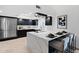 Modern kitchen featuring a waterfall island with bar seating, black cabinetry, and stainless steel appliances at 1509 W Kiowa Ave, Mesa, AZ 85202