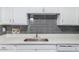 Modern kitchen with white cabinets, quartz countertops, and a gray subway tile backsplash at 15610 N 29Th St # 3, Phoenix, AZ 85032