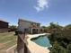 Serene backyard oasis boasting a pool, lush landscaping, and a charming two-story residence at 16784 W Polk St, Goodyear, AZ 85338