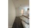 Carpeted hallway with white railing and neutral paint at 16784 W Polk St, Goodyear, AZ 85338