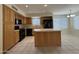 Eat-in kitchen featuring black appliances, an island, tile floors and light wood cabinets at 16784 W Polk St, Goodyear, AZ 85338