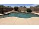 Backyard pool area showcasing a refreshing pool with rock features and a spacious concrete surround at 16784 W Polk St, Goodyear, AZ 85338