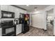 Efficient kitchen with black appliances, white cabinets, and wood-look flooring at 1700 S Martingale Rd, Gilbert, AZ 85295