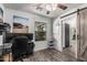 An office space with wood-look floors, barn door, and large wall decor at 1700 S Martingale Rd, Gilbert, AZ 85295