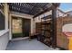 A concrete patio with a sliding glass door, dark wooden awning and workout equipment at 1700 S Martingale Rd, Gilbert, AZ 85295