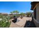 Paver patio backyard features a built-in grill and fire pit with seating and desert landscaping at 17516 W Glenhaven Dr, Goodyear, AZ 85338