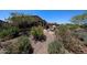 Beautiful home backyard featuring desert landscaping, a paver patio, fire pit, and seating area at 17516 W Glenhaven Dr, Goodyear, AZ 85338