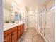 Bright bathroom with double sinks, a walk-in shower, and tile flooring at 17516 W Glenhaven Dr, Goodyear, AZ 85338