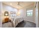 Cozy bedroom with carpet flooring, a ceiling fan, and a bright window at 17516 W Glenhaven Dr, Goodyear, AZ 85338