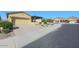 Landscaped desert front yard including a paved driveway, plants, and a tan exterior at 17516 W Glenhaven Dr, Goodyear, AZ 85338