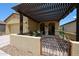 An exterior shot of a charming covered front porch featuring a metal gate and desert landscaping at 17516 W Glenhaven Dr, Goodyear, AZ 85338
