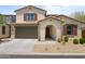 Charming two-story home features a two-car garage and a welcoming arched entryway, beautiful landscaping, and desert charm at 17721 W Cassia Way, Goodyear, AZ 85338