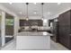 Modern kitchen featuring stainless steel appliances, a spacious island with pendant lighting, and sliding glass doors at 17721 W Cassia Way, Goodyear, AZ 85338