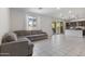 Bright, open-concept living room with a large sectional sofa, tile flooring, and sliding glass doors to the backyard at 17721 W Cassia Way, Goodyear, AZ 85338