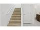 Carpeted stairs with white railing lead to the upper level, situated next to a bathroom and bedroom at 17721 W Cassia Way, Goodyear, AZ 85338