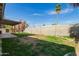 Spacious backyard with grass, patio area, and tall block wall offering privacy at 1845 N 64Th St, Scottsdale, AZ 85257
