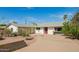 Single-story home with mature landscaping and a circular driveway at 1845 N 64Th St, Scottsdale, AZ 85257