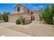 Desert landscaping and a two-car garage create curb appeal for this two-story home at 19230 N 5Th St, Phoenix, AZ 85024