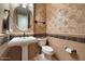 Elegant powder room with decorative wallpaper, pedestal sink, and updated fixtures, adding a touch of luxury at 2470 E Roma Ave, Phoenix, AZ 85016