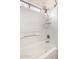 White shower-tub combo with white tile surround, shower head, and window at 2556 W Amber Sun Dr, Phoenix, AZ 85085