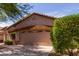 A neat two-car garage with decorative accents complements the well-manicured landscaping at 2556 W Amber Sun Dr, Phoenix, AZ 85085