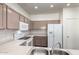 Updated kitchen with stainless steel sink, white appliances, and neutral cabinets and countertops at 2556 W Amber Sun Dr, Phoenix, AZ 85085