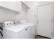 Laundry room featuring a modern washer and dryer set, storage, and exterior door at 2556 W Amber Sun Dr, Phoenix, AZ 85085