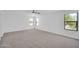 Bright bedroom features plush carpeting, three windows, and neutral decor at 25726 W Burgess Ln, Buckeye, AZ 85326